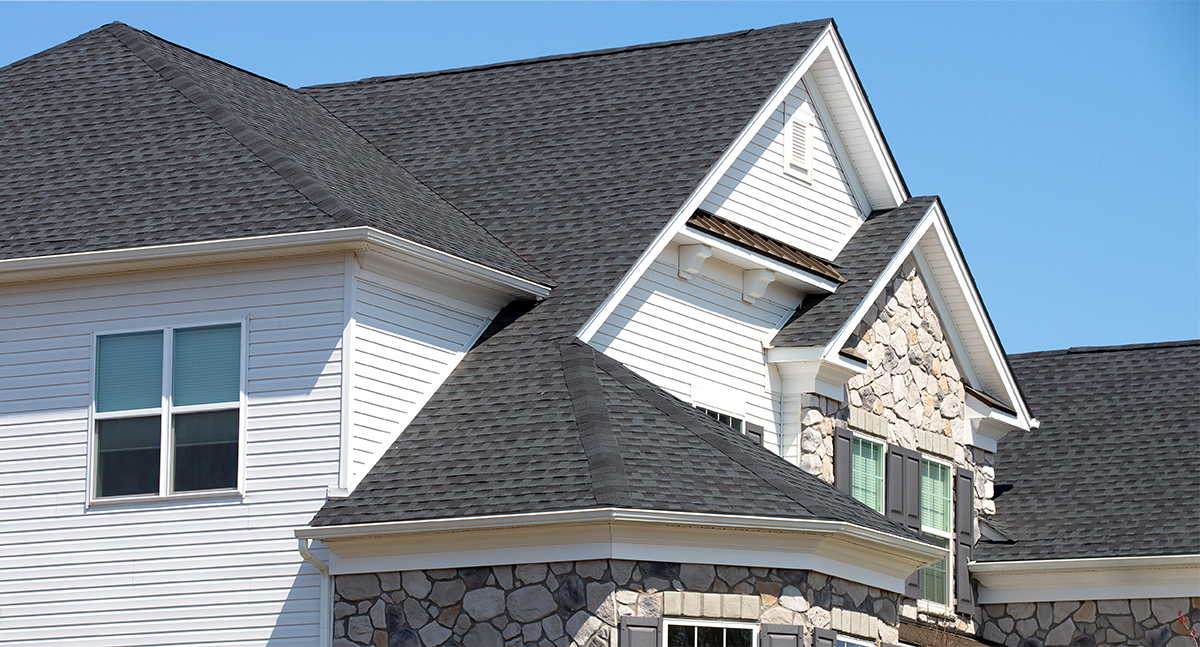 The exterior of a stone and vinyl houses while home inspection services are being completed